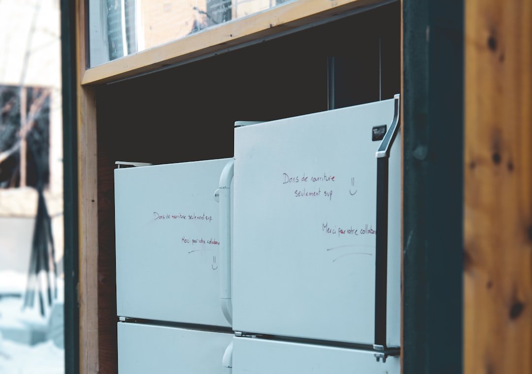Organized freezer with labeled containers and a whiteboard inventory list on the door